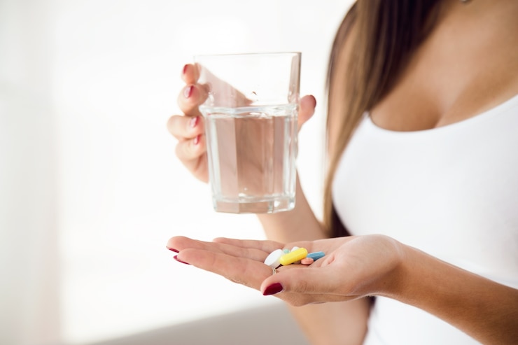 Young woman taking pills at home.
