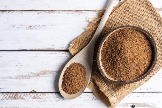 Coconut palm sugar on a wooden spoon isolated on white background