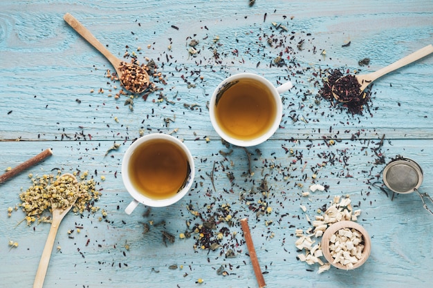 Two cup of tea in ceramic bowl with dried chinese chrysanthemum flowers and herbs on table