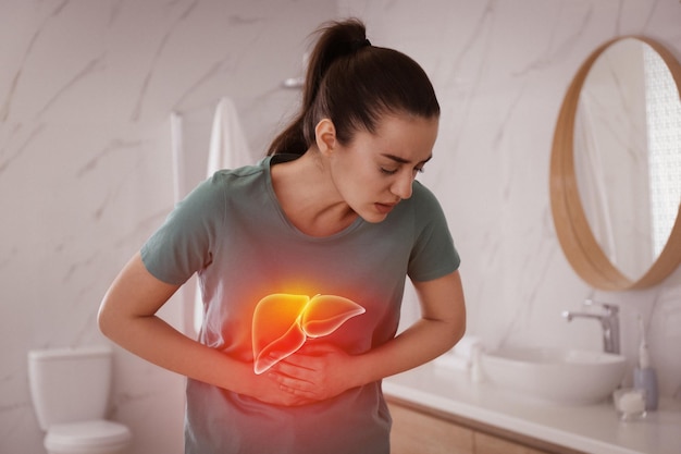 Sick woman suffering from pain in bathroom and illustration of unhealthy liver Hepatitis disease